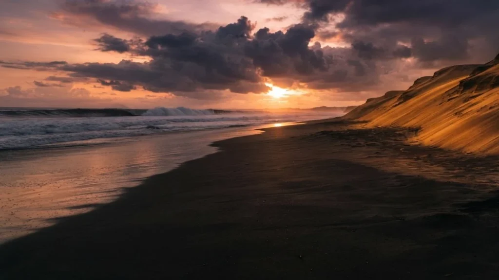 Parangtritis Beach Yogyakarta black volcanic sand and sand dunes at sunset with Indian Ocean waves